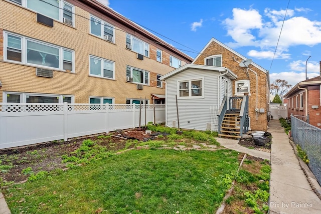 rear view of property featuring a lawn