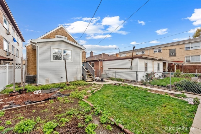 rear view of property with a yard and central AC