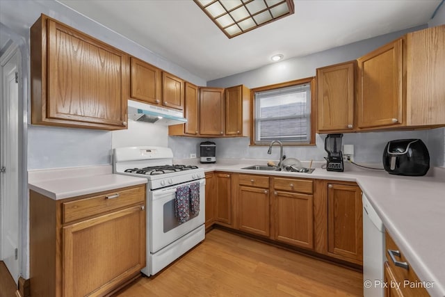 kitchen with light wood-type flooring, white appliances, and sink