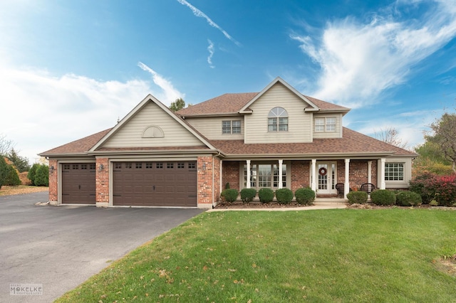 view of front of house with a front yard, a garage, and covered porch