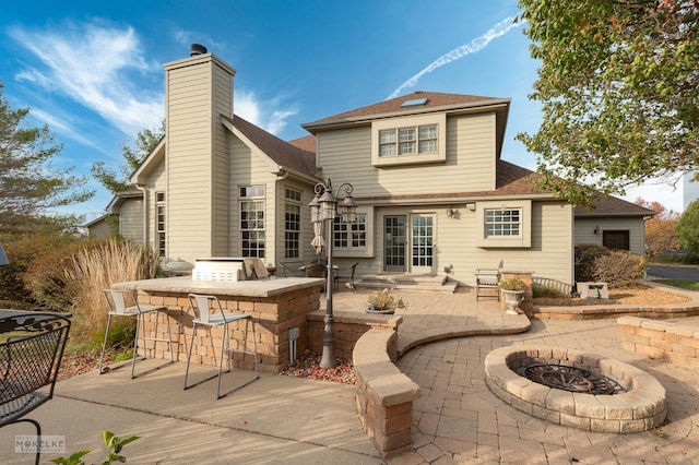 back of property with area for grilling, a bar, and a patio