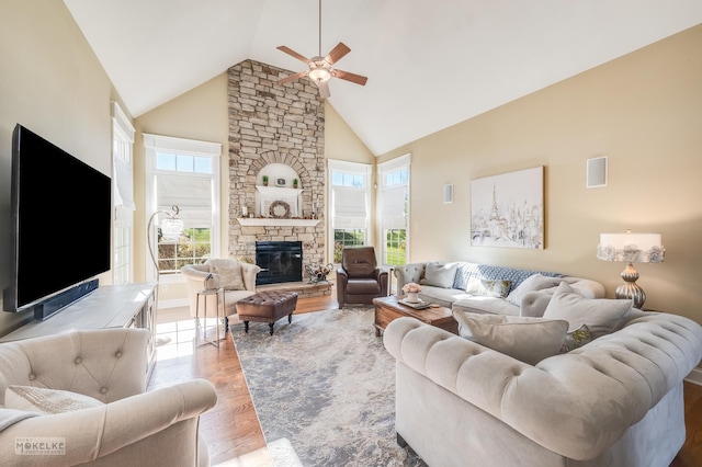 living room featuring a fireplace, light hardwood / wood-style floors, high vaulted ceiling, and ceiling fan