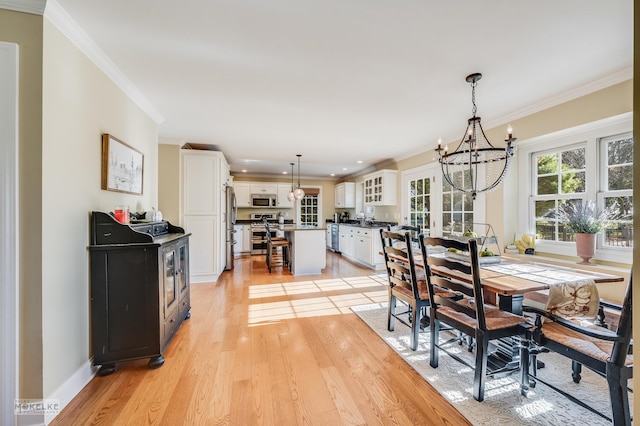 dining area with a chandelier, light hardwood / wood-style flooring, and ornamental molding