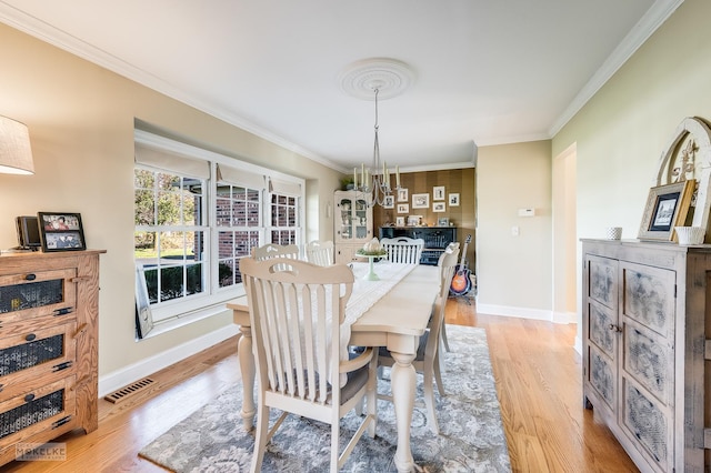 dining area featuring light hardwood / wood-style flooring and ornamental molding