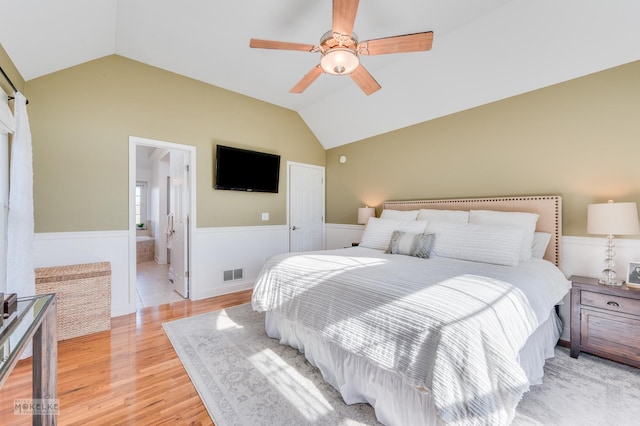 bedroom with connected bathroom, ceiling fan, light hardwood / wood-style flooring, and vaulted ceiling