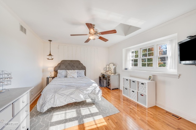 bedroom featuring ceiling fan, crown molding, and light wood-type flooring