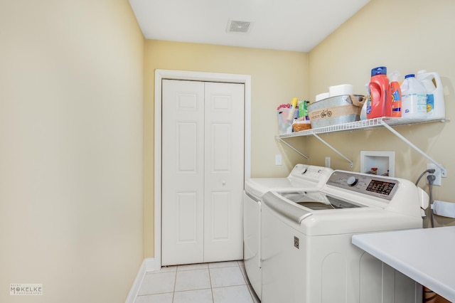 laundry room with light tile patterned floors and washer and dryer