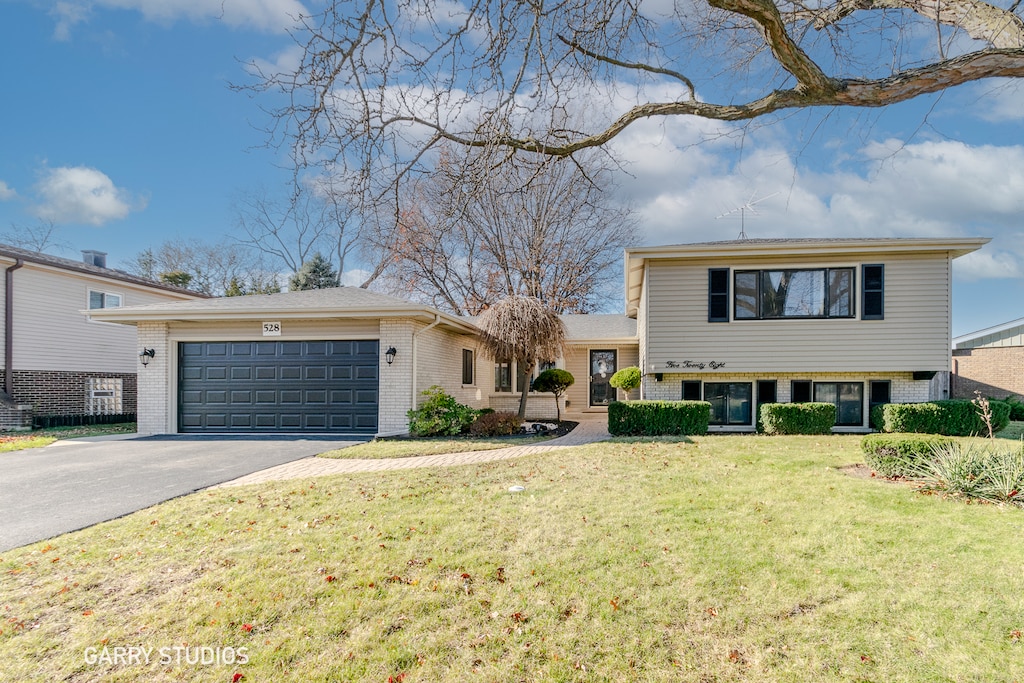 split level home featuring a front lawn and a garage