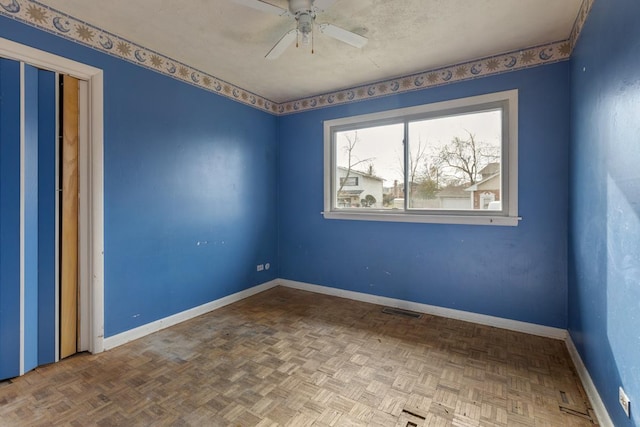 unfurnished room featuring parquet flooring and ceiling fan