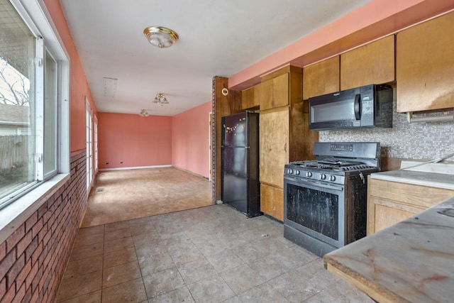 kitchen with decorative backsplash, light carpet, and black appliances