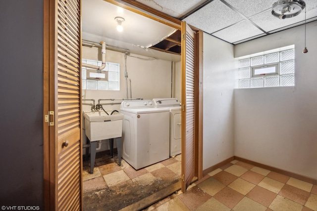 laundry room with washing machine and dryer, a healthy amount of sunlight, and sink