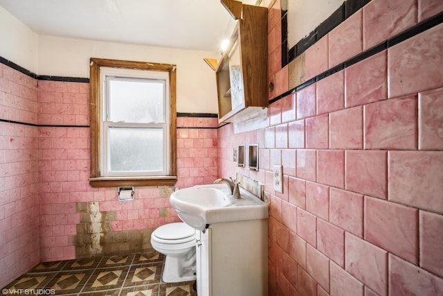 bathroom with tile patterned floors, vanity, tile walls, and toilet