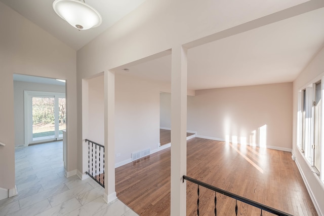 hallway featuring light hardwood / wood-style flooring and vaulted ceiling