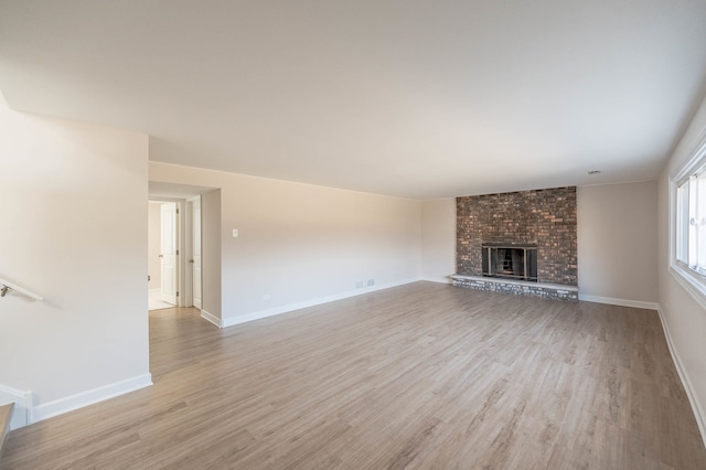 unfurnished living room with a fireplace and light hardwood / wood-style flooring