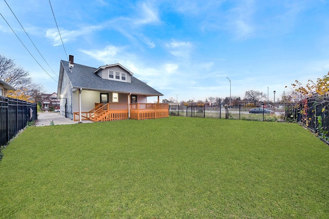 back of property with a yard and a wooden deck