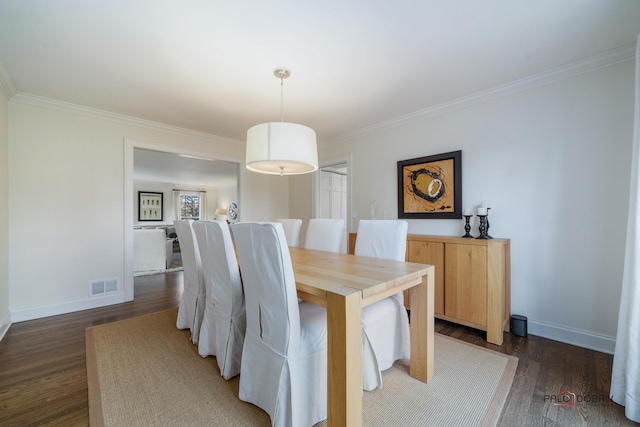 dining room featuring dark hardwood / wood-style flooring and ornamental molding