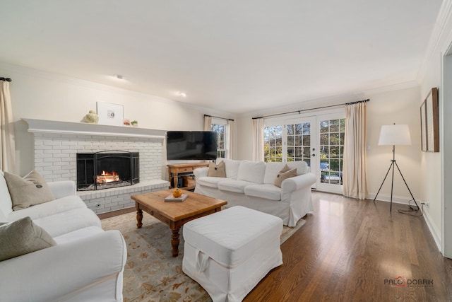 living room featuring crown molding, wood-type flooring, a fireplace, and french doors