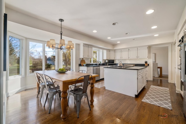 dining space with dark hardwood / wood-style flooring, sink, and an inviting chandelier