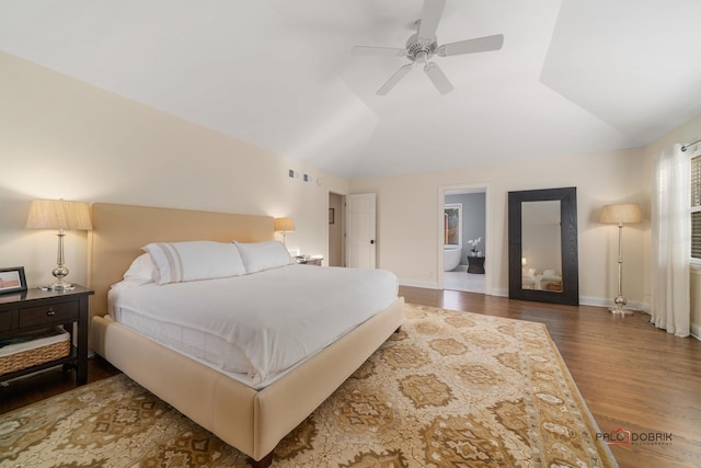 bedroom featuring ensuite bath, ceiling fan, dark wood-type flooring, and lofted ceiling