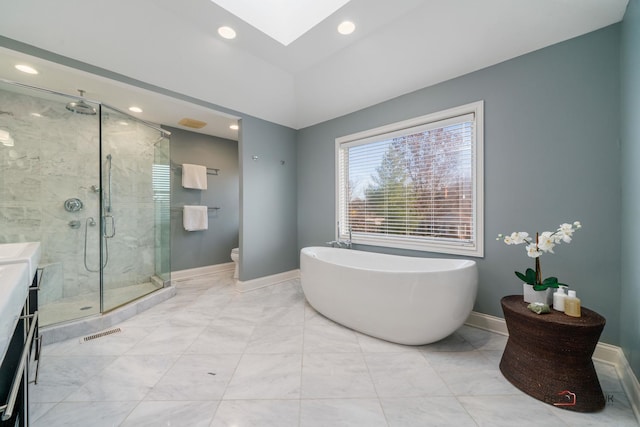 full bathroom featuring toilet, vanity, a skylight, and separate shower and tub