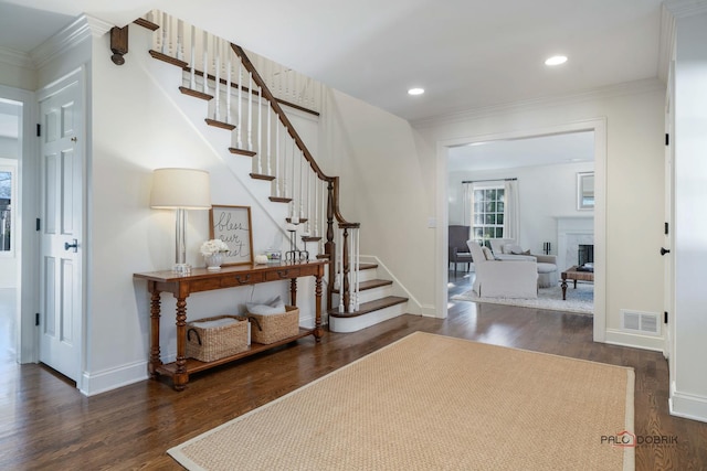 entryway with dark hardwood / wood-style flooring and crown molding