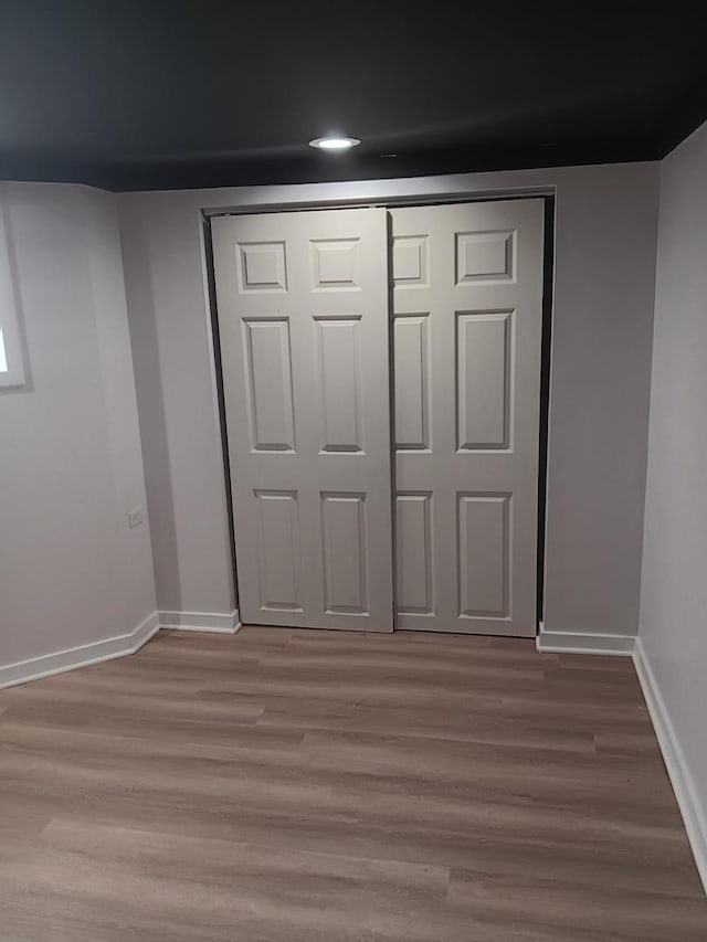 unfurnished bedroom with wood-type flooring and a closet