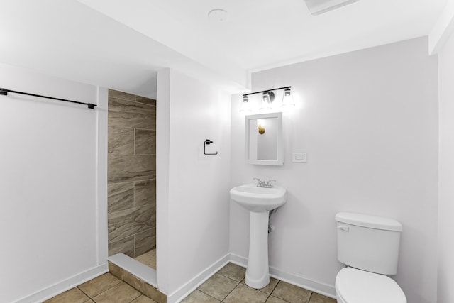 bathroom featuring tile patterned floors, toilet, and tiled shower