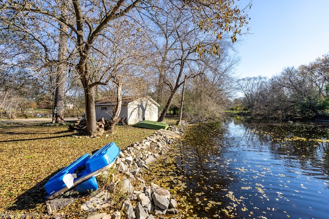 view of yard with a storage unit and a water view