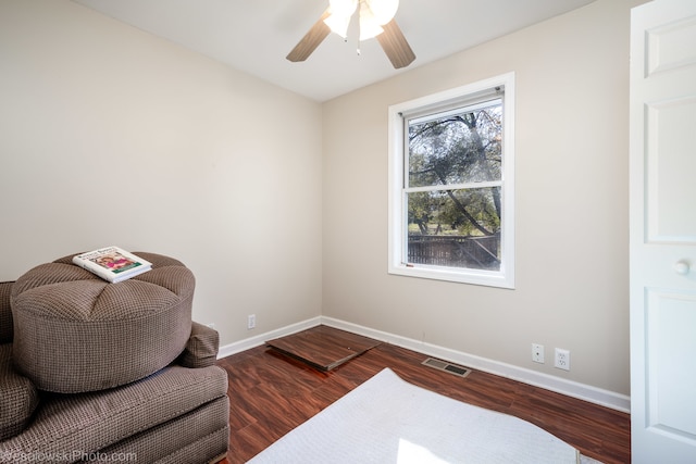 living area with ceiling fan and dark wood-type flooring