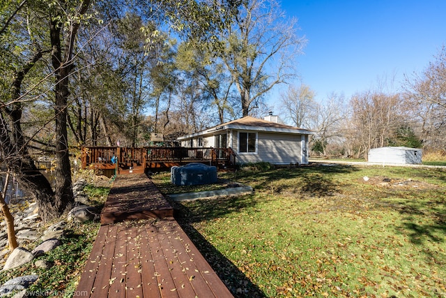 back of property featuring a wooden deck and a yard