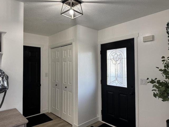 foyer entrance with hardwood / wood-style floors and a textured ceiling