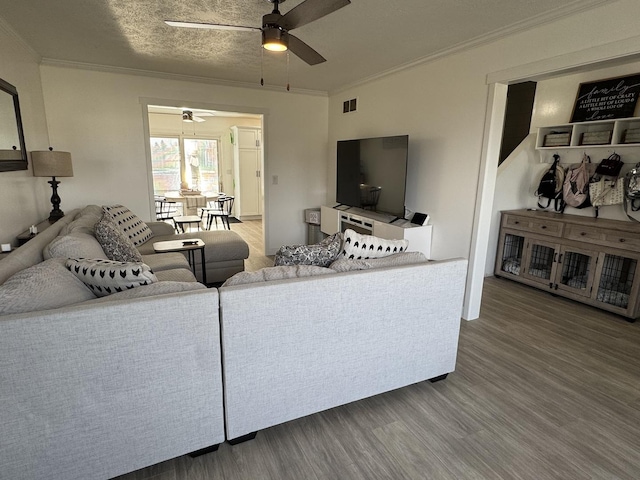 living room featuring hardwood / wood-style flooring, ceiling fan, and crown molding