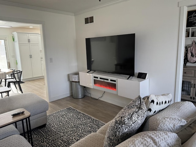 living room with crown molding and light wood-type flooring