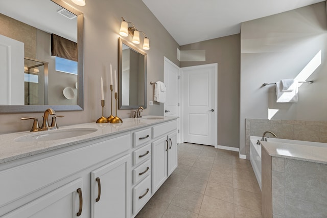 bathroom with vanity, a tub to relax in, tile patterned floors, and a skylight