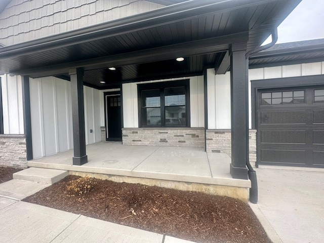 entrance to property featuring a porch and a garage