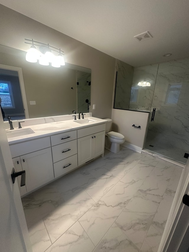 bathroom featuring a shower with door, vanity, and toilet