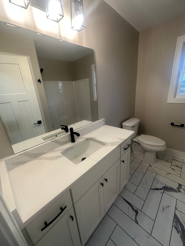 bathroom featuring toilet, a shower, and vanity