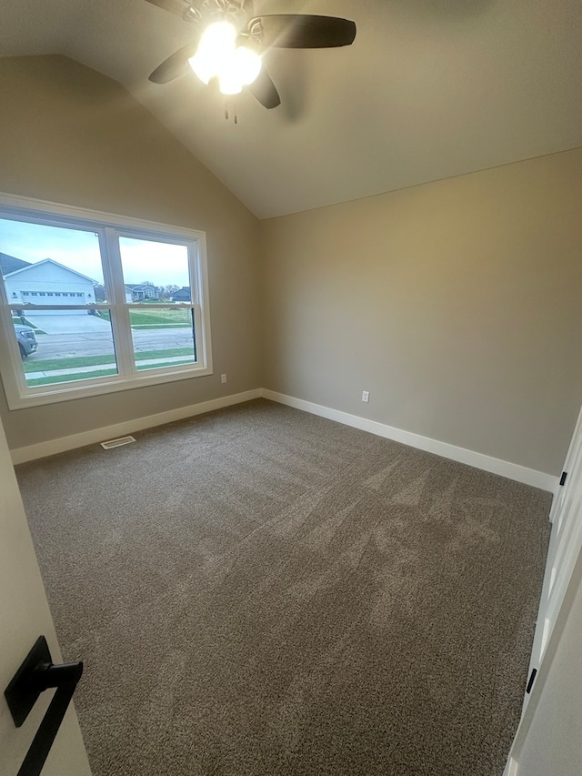 carpeted spare room with ceiling fan and vaulted ceiling