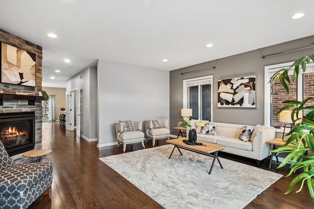 living area featuring baseboards, a fireplace, wood finished floors, and recessed lighting