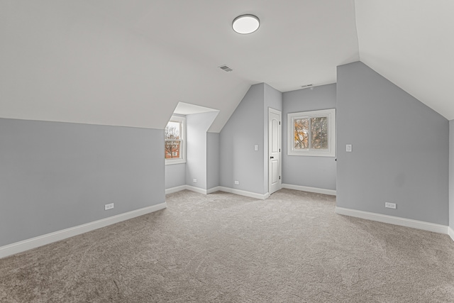 additional living space with lofted ceiling and light carpet