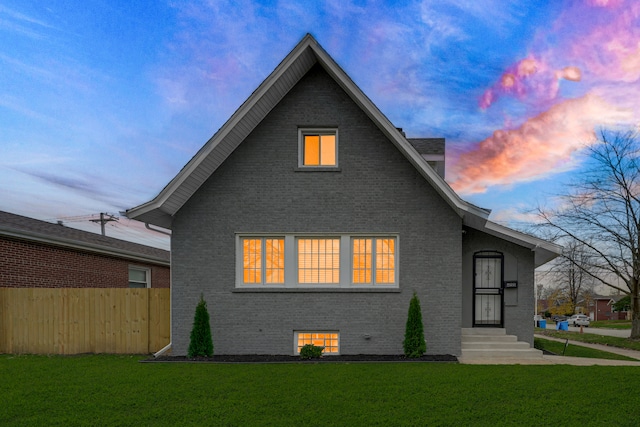 back house at dusk featuring a yard