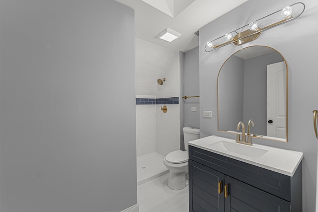 bathroom featuring tile patterned flooring, vanity, toilet, and tiled shower