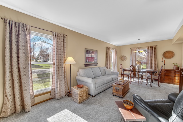 living room with a chandelier, carpet floors, and a healthy amount of sunlight