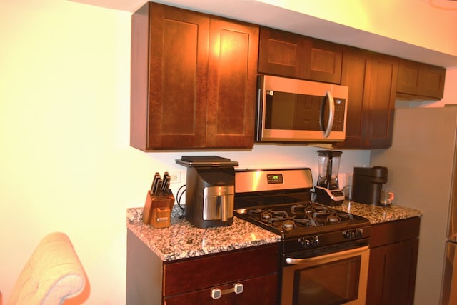 kitchen with light stone countertops and stainless steel appliances