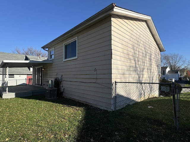 view of side of home with a yard and central AC unit