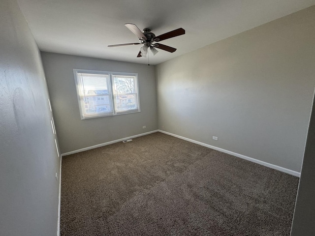 empty room featuring dark carpet and ceiling fan