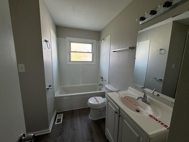 full bathroom with vanity, hardwood / wood-style flooring, toilet, a textured ceiling, and shower / bath combination