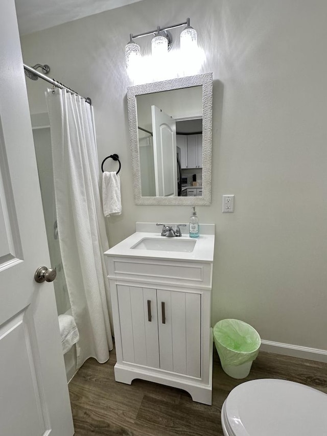 full bathroom with vanity, hardwood / wood-style flooring, toilet, and shower / bath combo with shower curtain