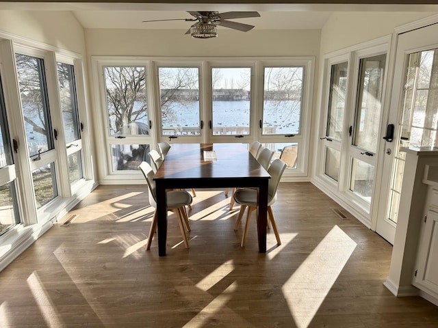 sunroom with ceiling fan, a healthy amount of sunlight, and a water view