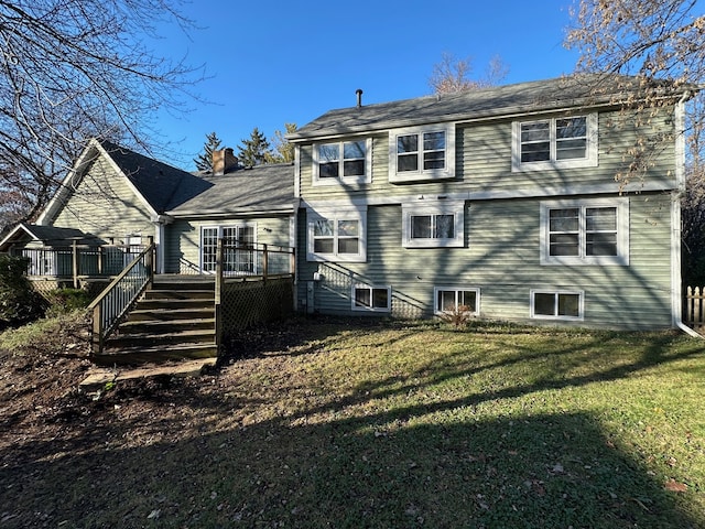 rear view of property featuring a deck and a lawn